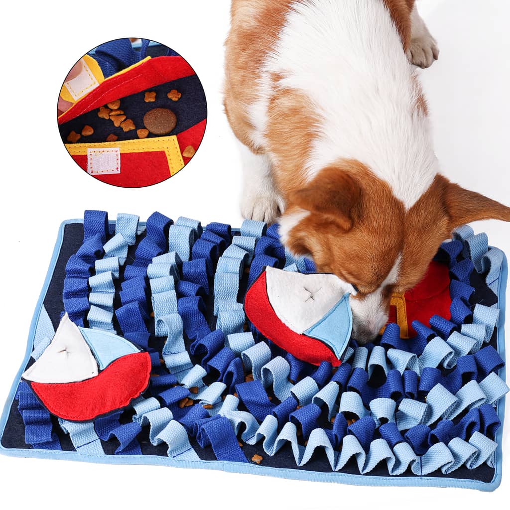 Corgi der snuser efter godbidder i blåt snusetæppe der forestiller en havbund med skibe