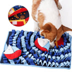 Corgi der snuser efter godbidder i blåt snusetæppe der forestiller en havbund med skibe